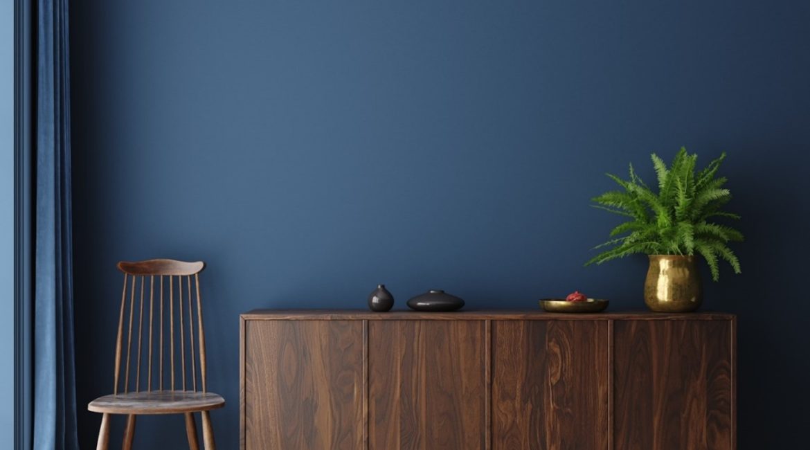 Wooden cabinet sitting against a beautiful blue wall